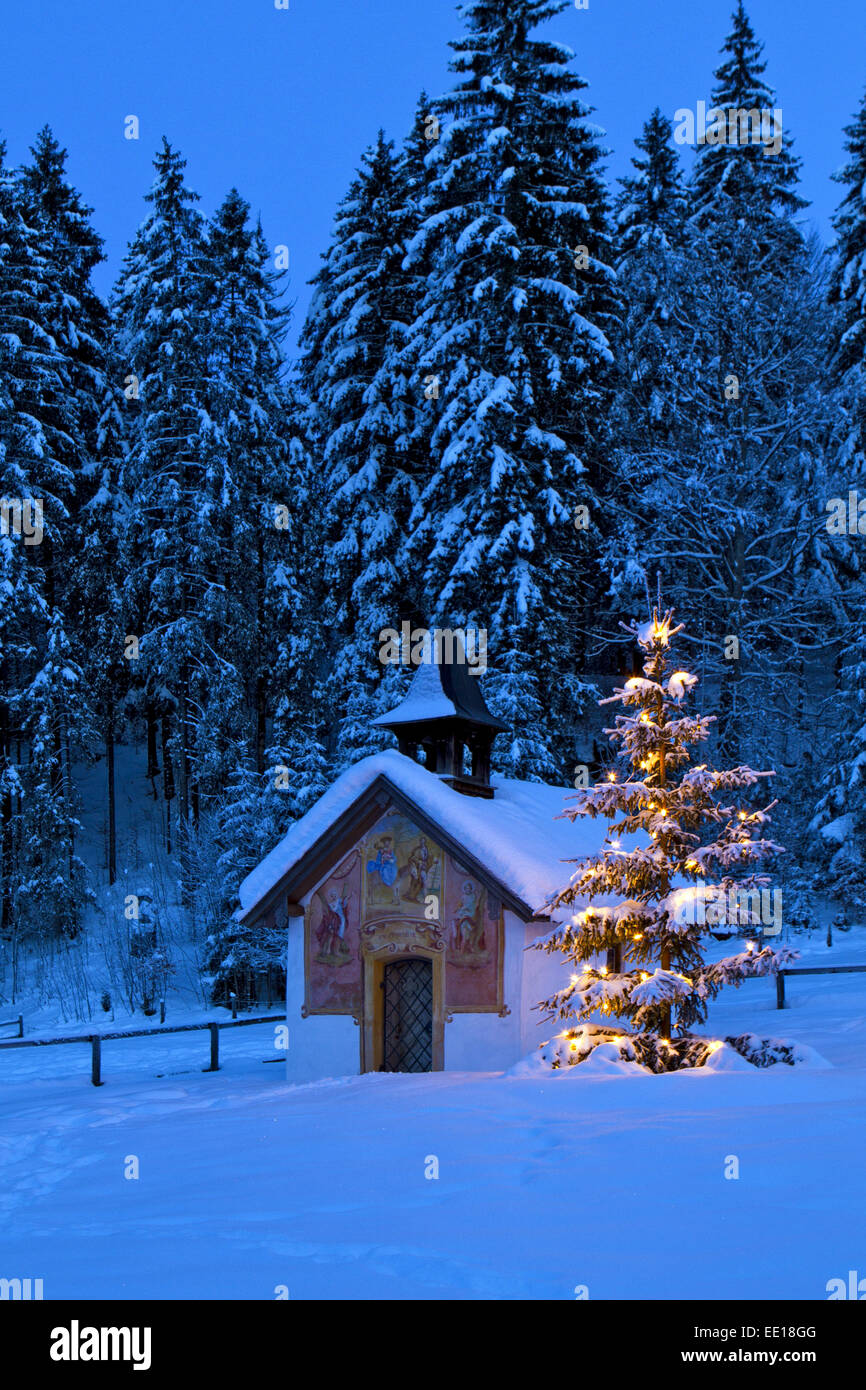 Beleuchteter Christbaum vor einer Kapelle in Bayern Foto Stock
