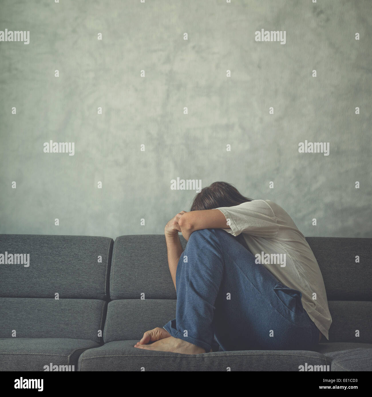 Triste e depresso uomo sul lettino in camera, che ricopre la faccia e a piangere in preda alla disperazione. Foto Stock