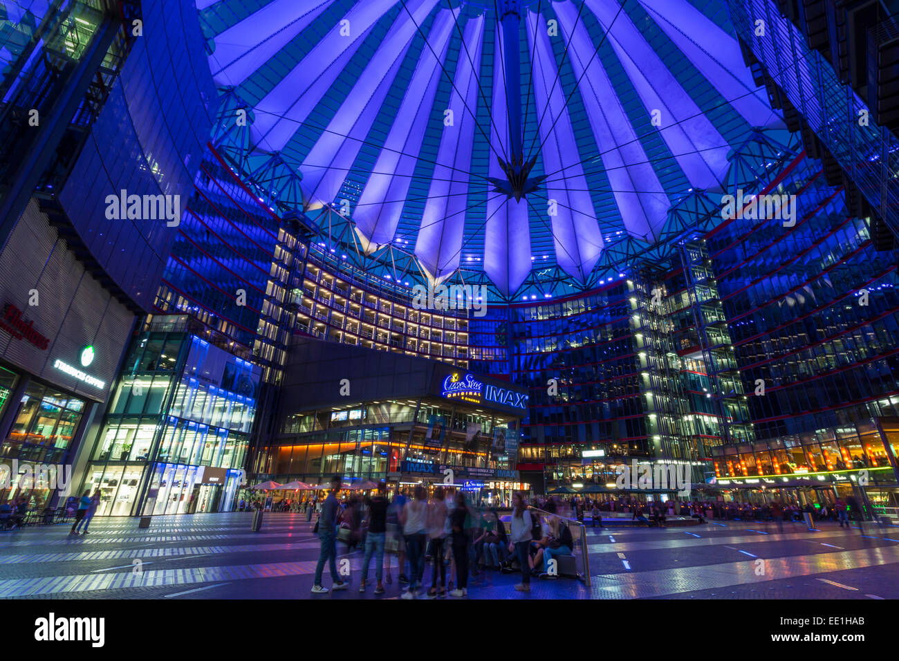Giovani rilassarsi e socializzare in una accesa il Sony Center di notte, Potsdamer Platz, Berlin, Germania, Europa Foto Stock