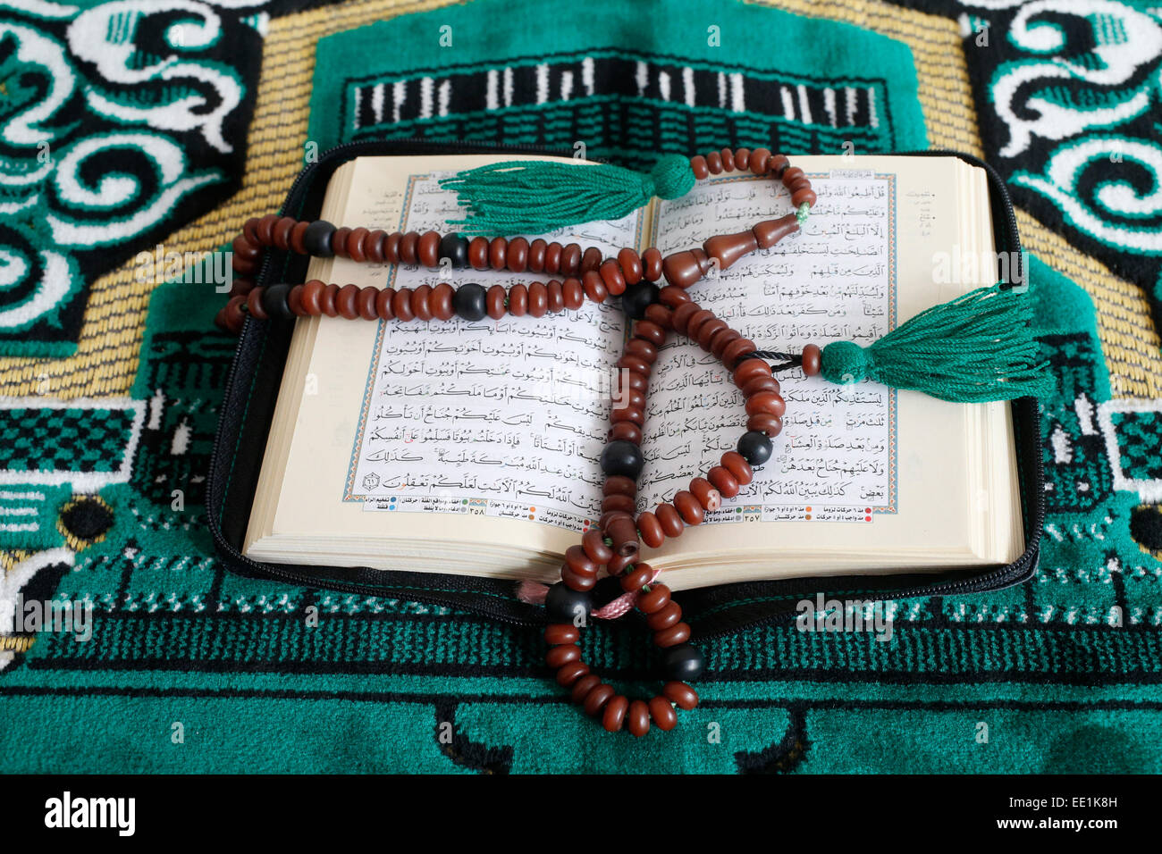 Corano e di preghiera islamica perle su un tappeto da preghiera, Parigi, Francia, Europa Foto Stock