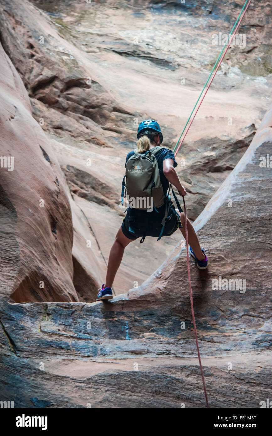 Donna rapelling verso il basso nello slot canyon, canyoning, Moab, Utah, Stati Uniti d'America, America del Nord Foto Stock