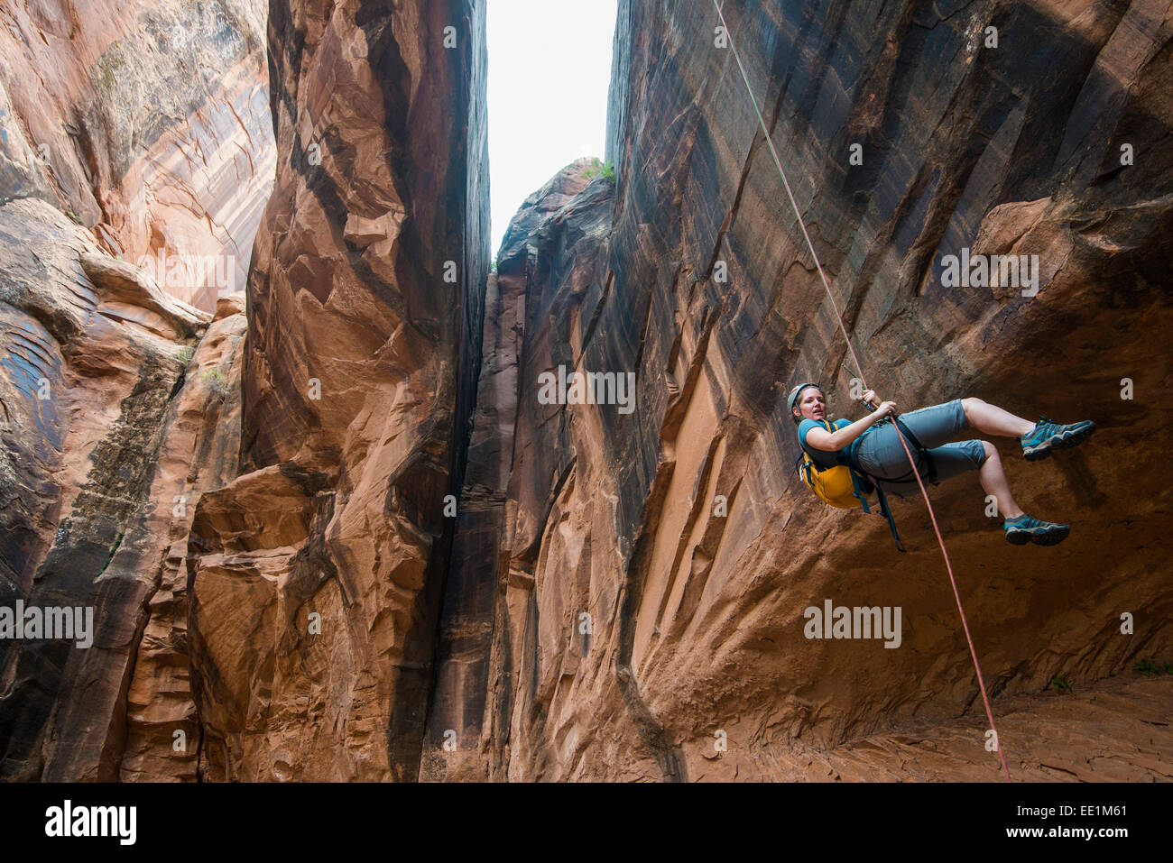 Donna rapelling giù un arco gigante, canyoning, Moab, Utah, Stati Uniti d'America, America del Nord Foto Stock