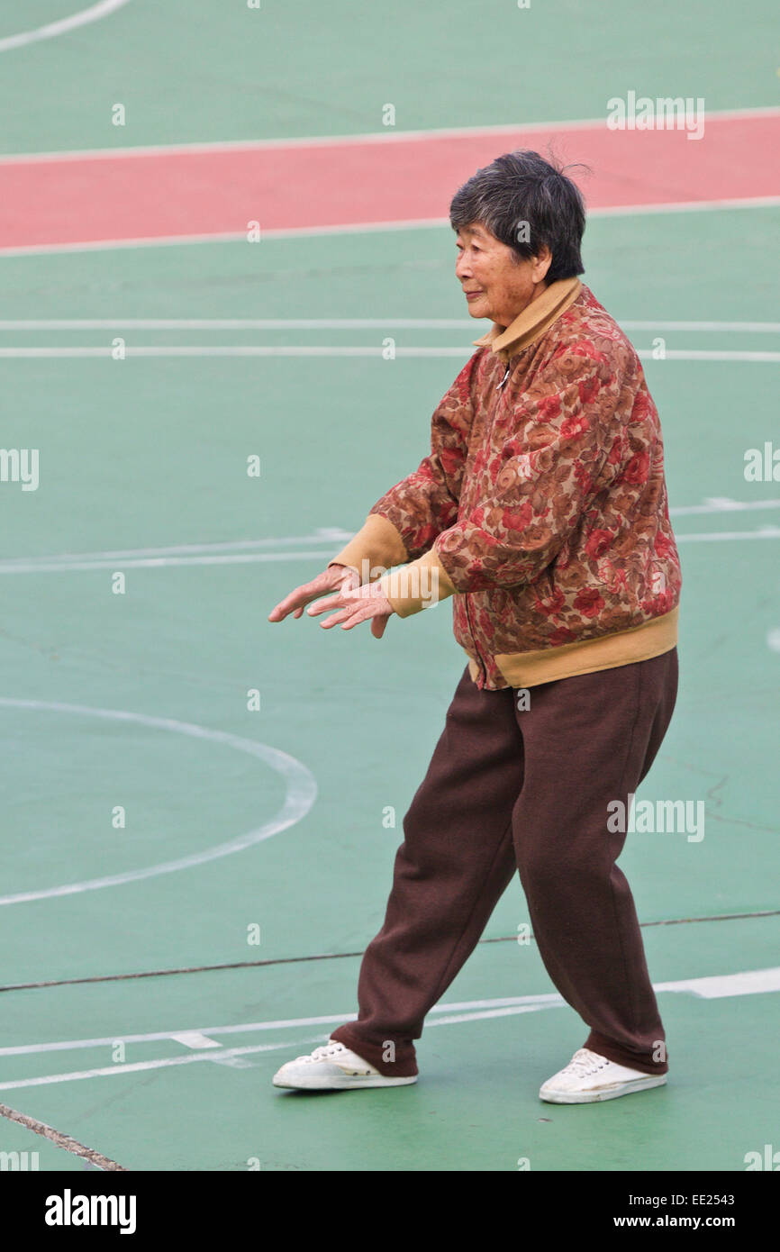 Donna cinese esegue il suo mattina Tai Chi su Cheung Chau Isola, Hong Kong. Foto Stock