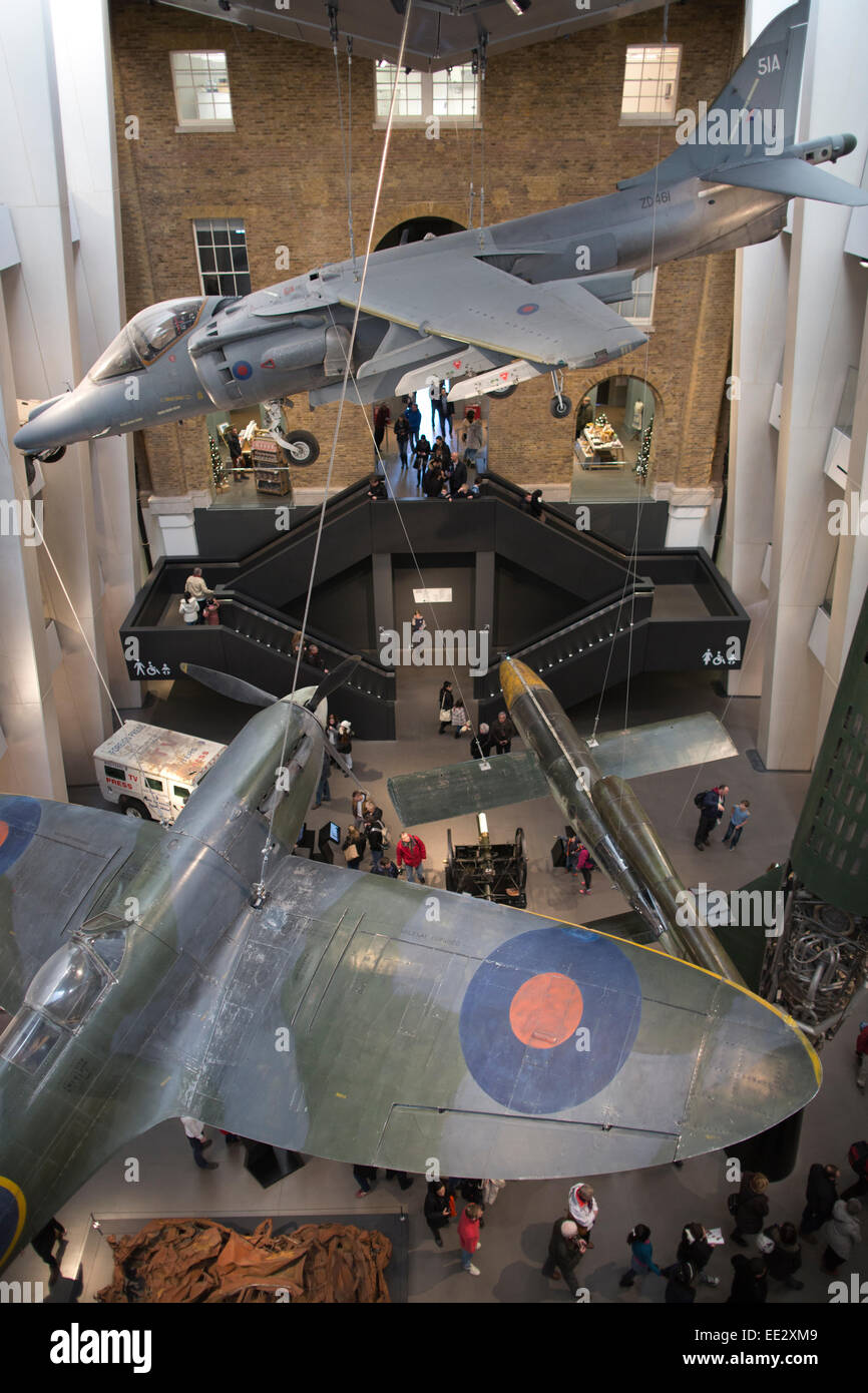 Harrier e velivoli Spitfire appeso in atrio, esposto presso l'Imperial War Museum di Londra, IWM London, England, Regno Unito Foto Stock