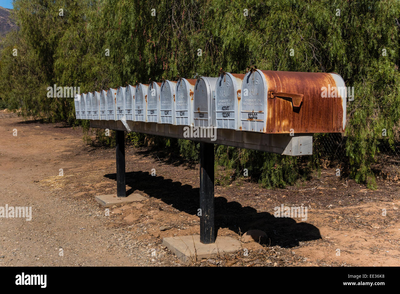 Una fila di identici arrugginendo metallo scatole lungo una strada di campagna al di fuori di Ojai, California. Foto Stock