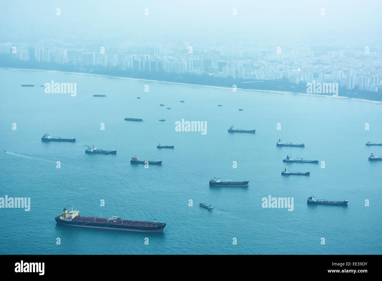 Grande raccolta di commerciale navi cargo in attesa presso l'ancoraggio appena al largo della costa di Singapore. Foto Stock
