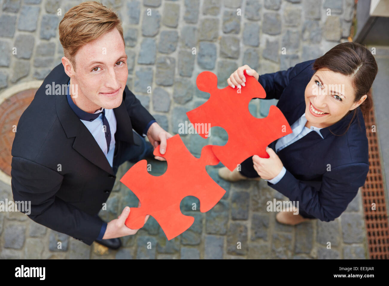 Uomo sorridente e donna felice azienda big red puzzle di pezzi Foto Stock