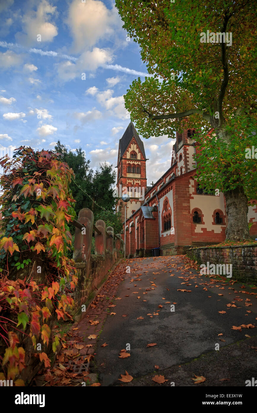 San Lutwinus chiesa e la strada con foglie a Mettlach, Germania Foto Stock