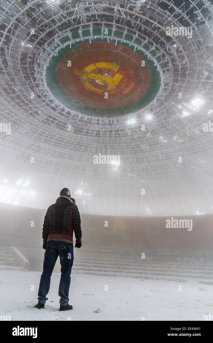 Un uomo che guarda il grande tetto di Buzludzha (monumento comunista) in Bulgaria Foto Stock