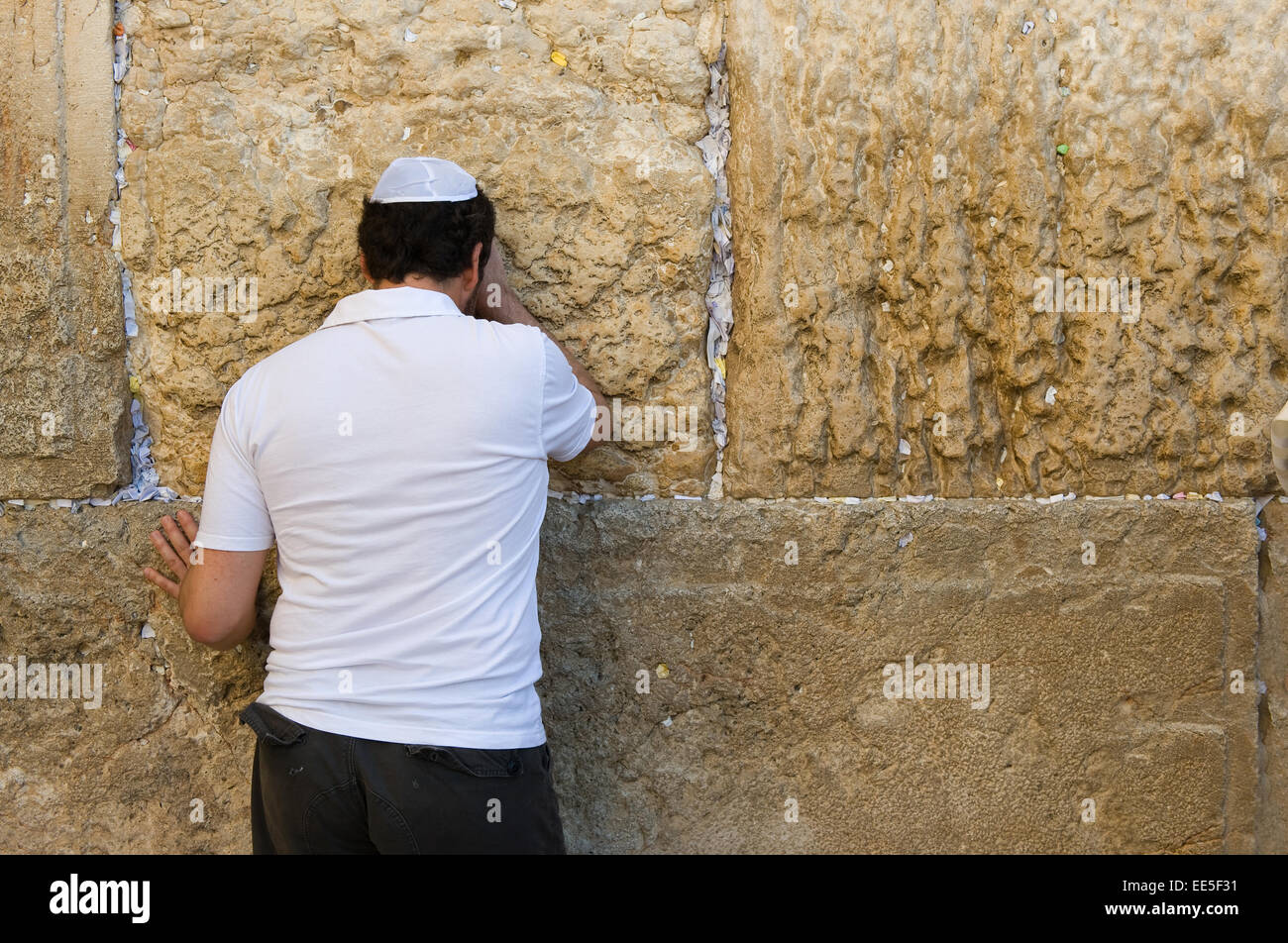 Un uomo ebraico è pregare contro il muro occidentale nella città vecchia di Gerusalemme Foto Stock