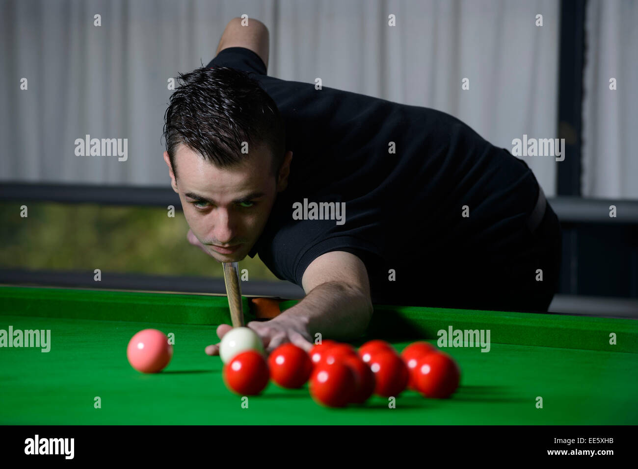 Giovane uomo giocare biliardo Foto Stock