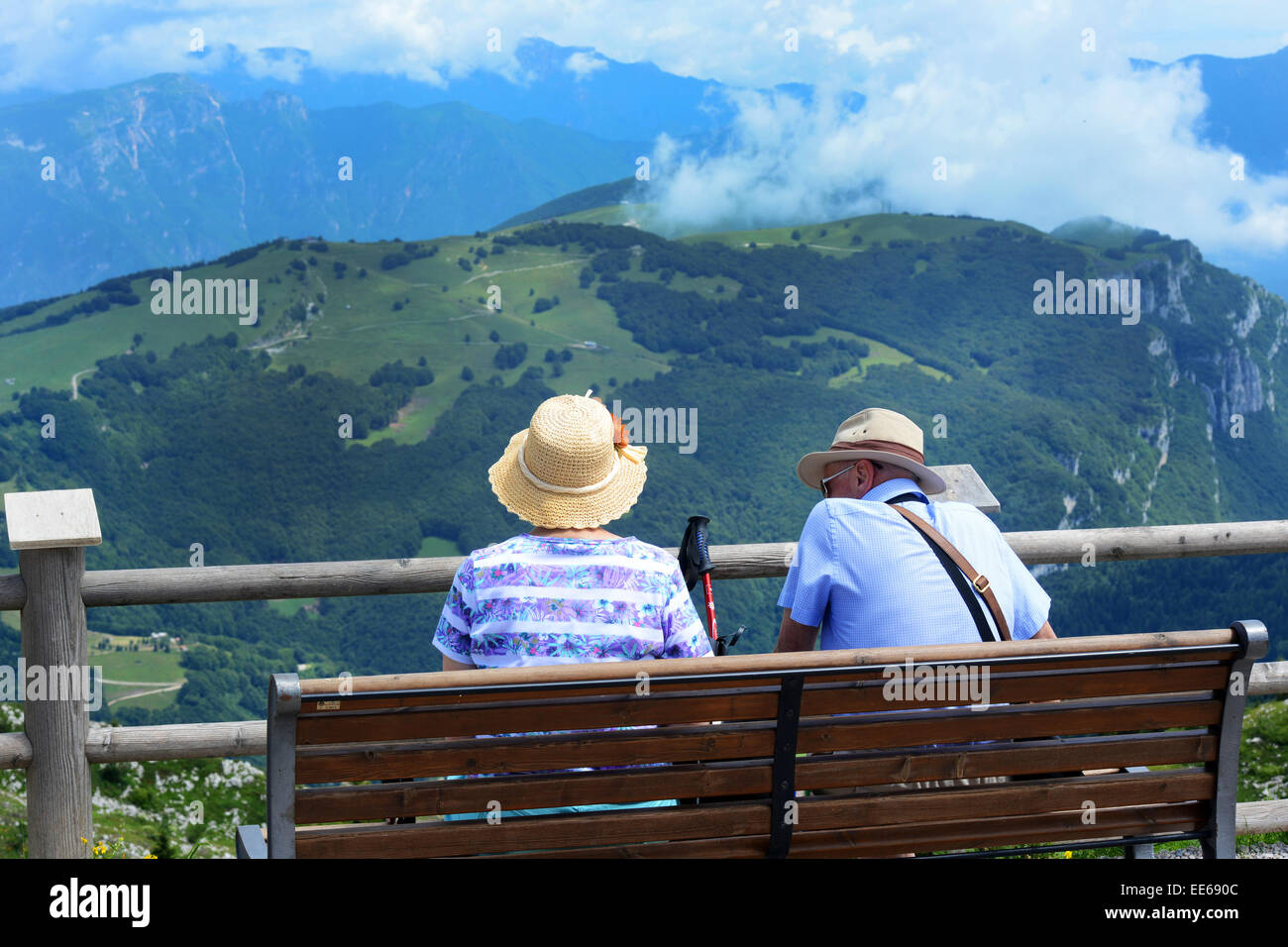 Coppia in pensione riposo su una panchina in montagna italiana, il Lago di Garda Foto Stock
