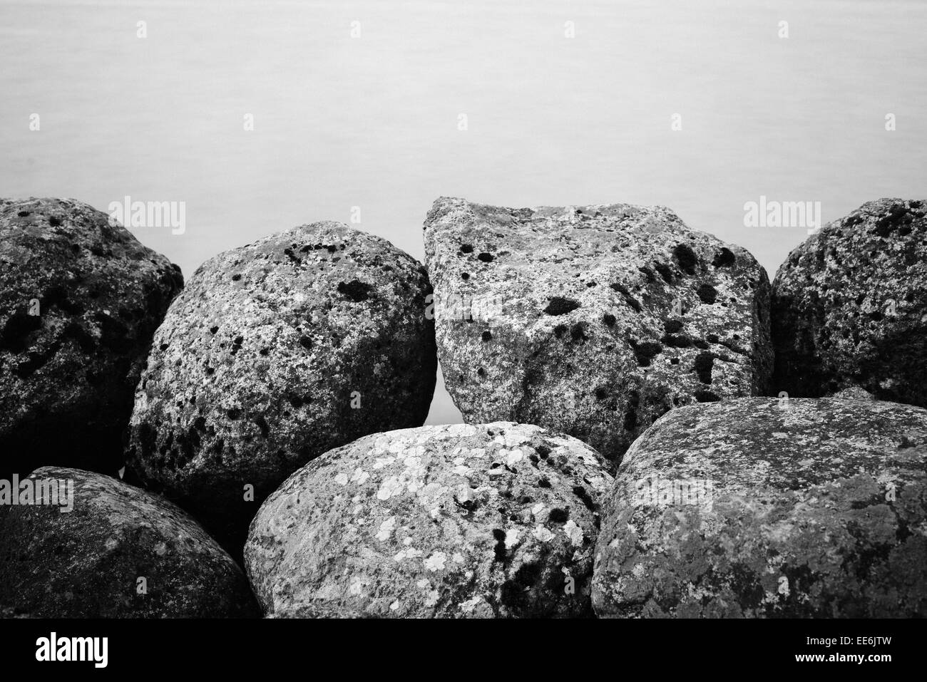 Natura tranquilla scena con una lunga esposizione di rocce scure e ancora acqua Foto Stock