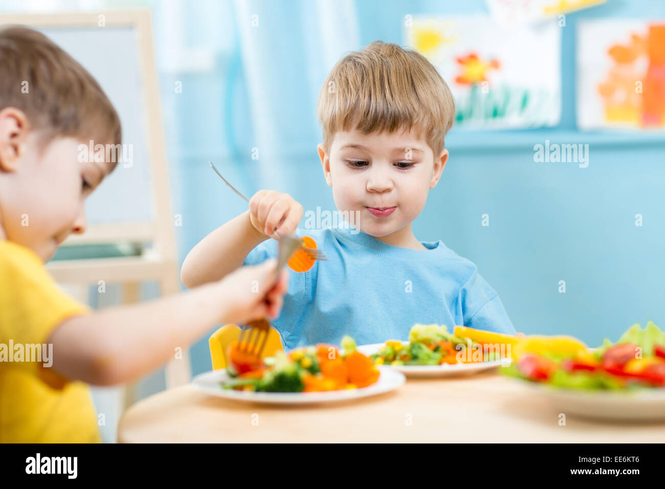I bambini a mangiare in una scuola materna Foto Stock