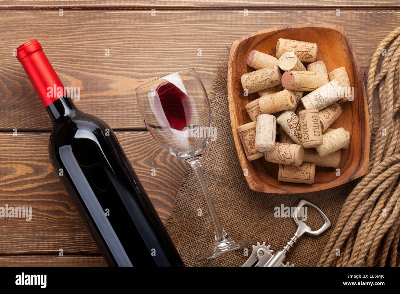 Vino rosso bottiglia, bicchiere di vino, ciotola con tappi di sughero e un  cavatappi. Vista da sopra su tavola in legno rustico sfondo Foto stock -  Alamy