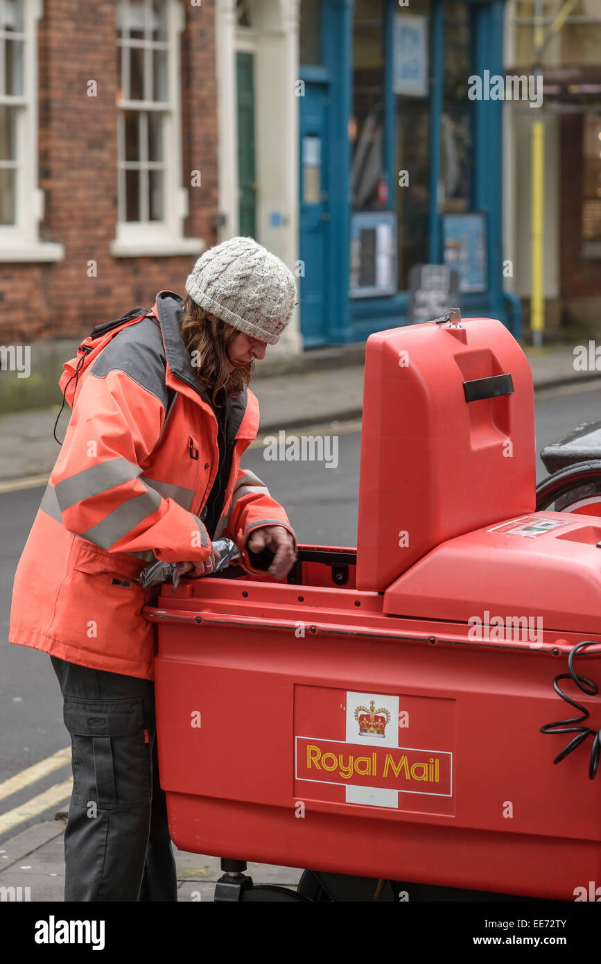 Un Royal Mail postwoman ordina la posta in un carro utilizzato per il centro città delle consegne. Foto Stock