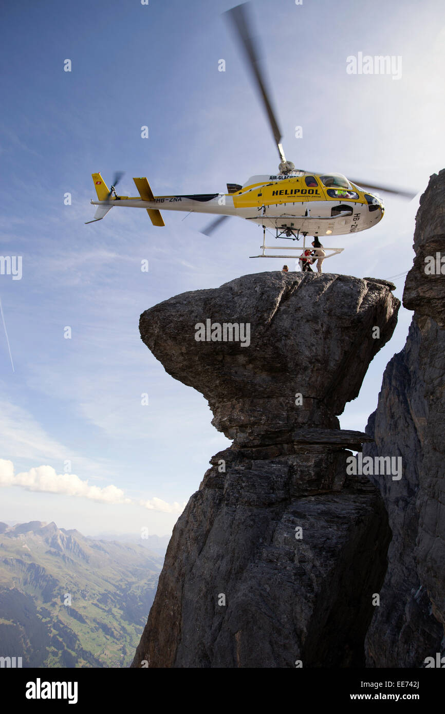 Un elicottero è in bilico su una roccia spettacolare. In tal modo di un ponticello di base è di uscire dalla cabina. Egli farà un salto dalla rupe Foto Stock