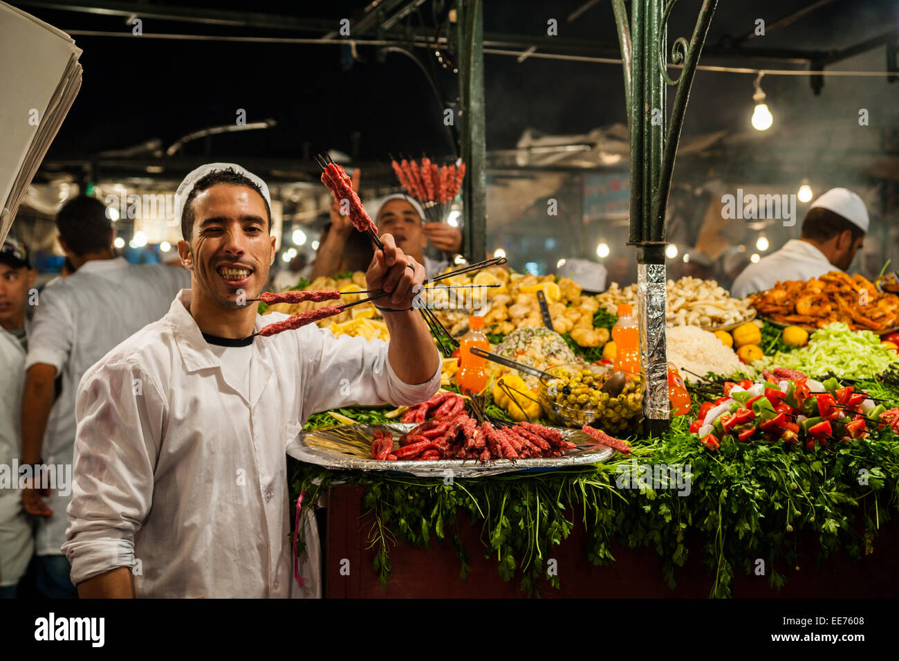I camerieri che mostra le materie di spiedini per attirare i clienti in Piazza Jemaa El Fnaa , un punto di riferimento UNESCO a Marrakech, Marocco Foto Stock