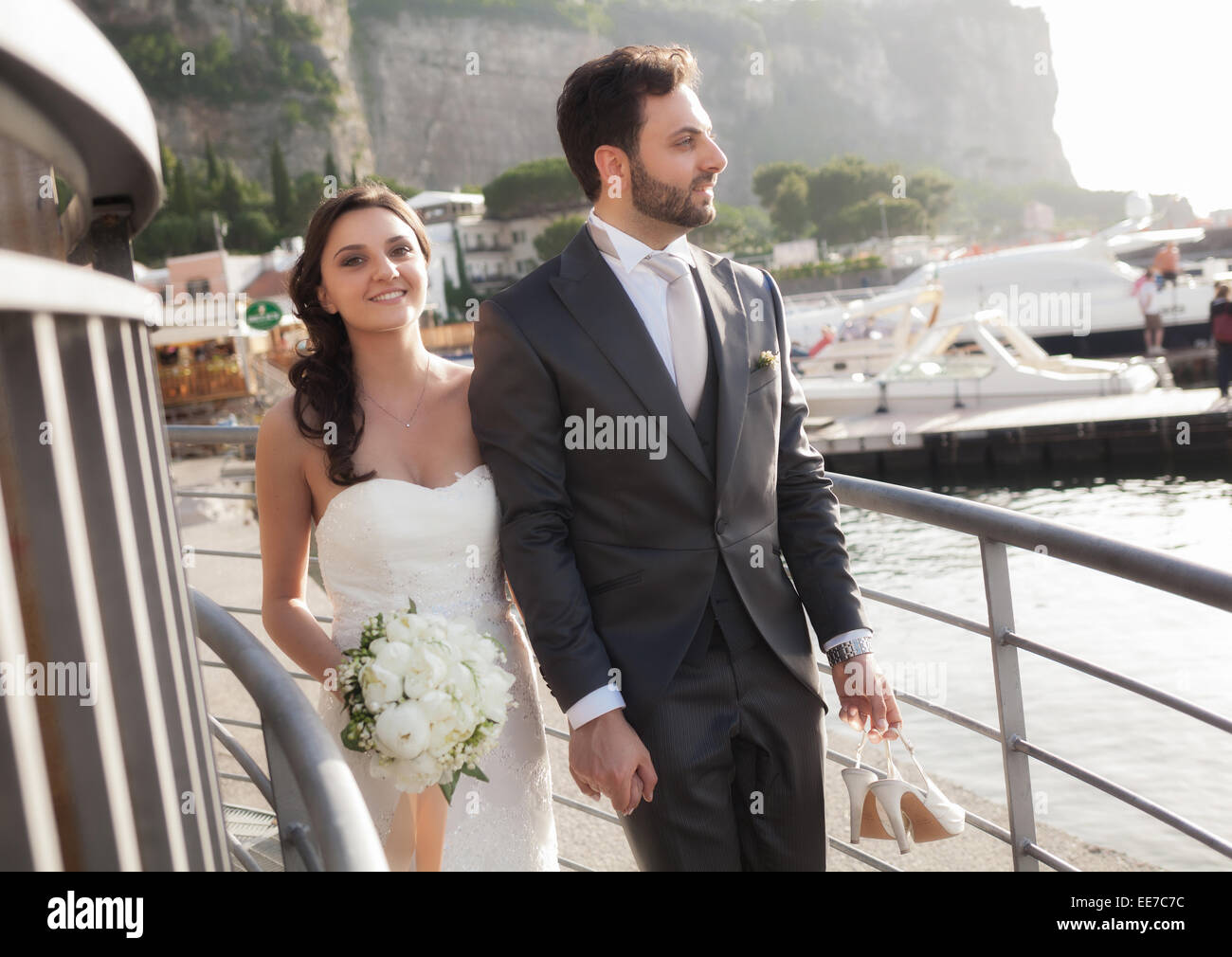 Coppia sposata nel giorno del loro matrimonio mentre passeggiando vicino al mare. Foto Stock