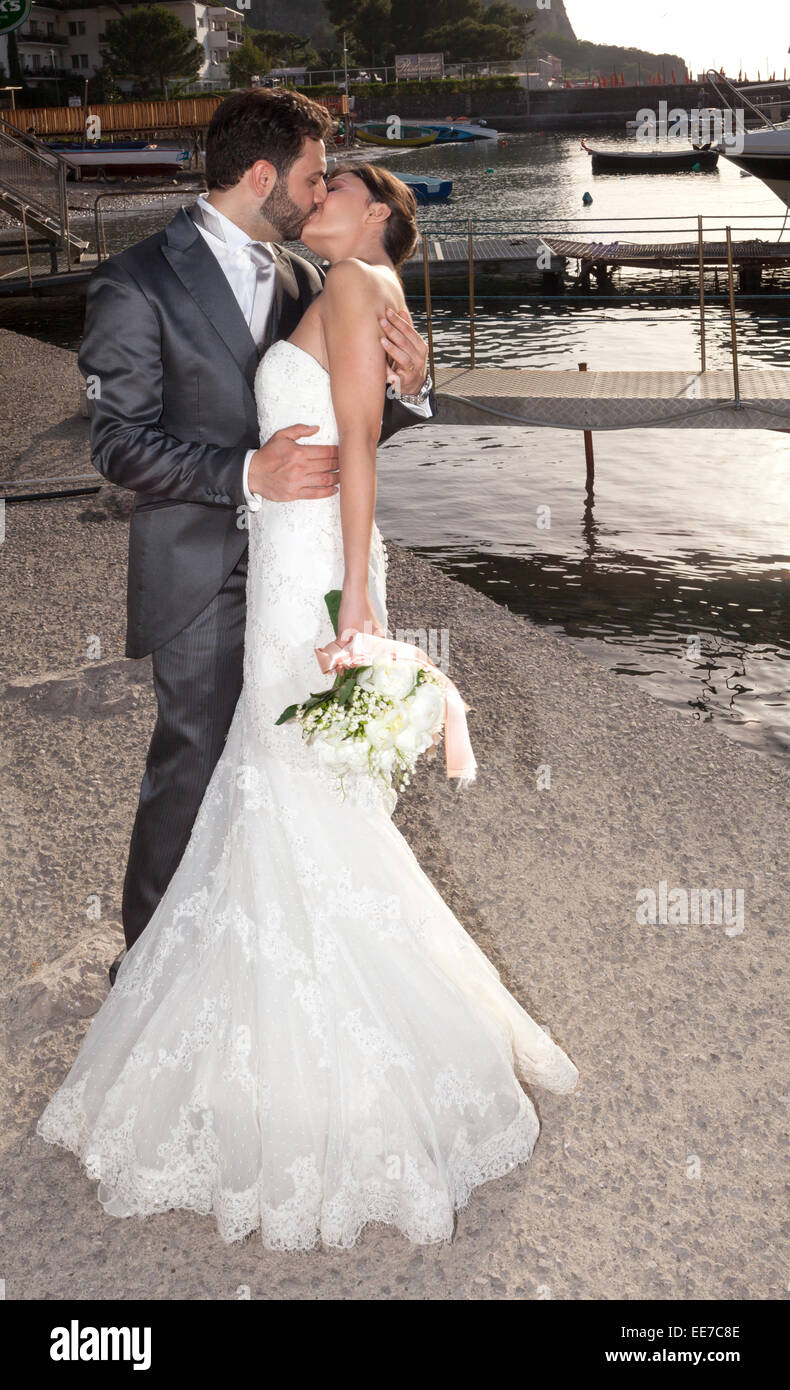 Coppia sposata nel giorno del loro matrimonio mentre baciare vicino al mare. Foto Stock