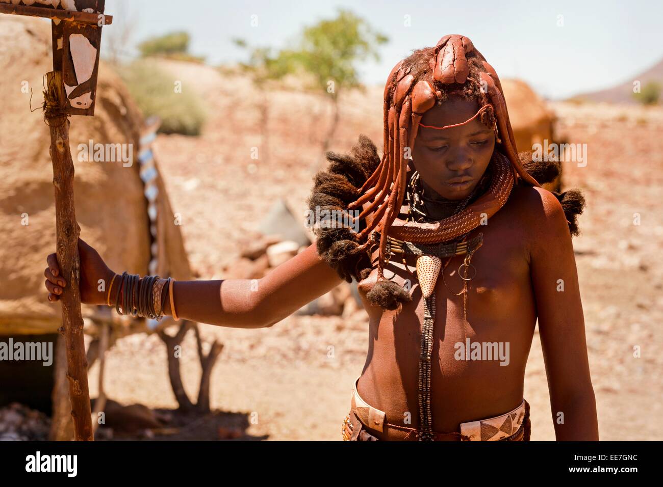 Una giovane donna appartenente al indigeni popolo Himba raffigurata nel suo villaggio nel nord della Namibia. Foto Stock