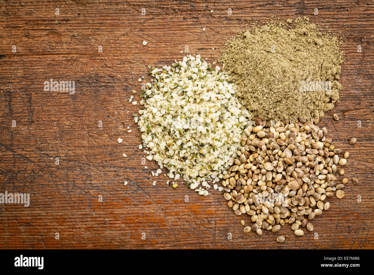 I semi di canapa, cuori e proteine in polvere - piccole pile su di un legno di grunge - vista superiore Foto Stock