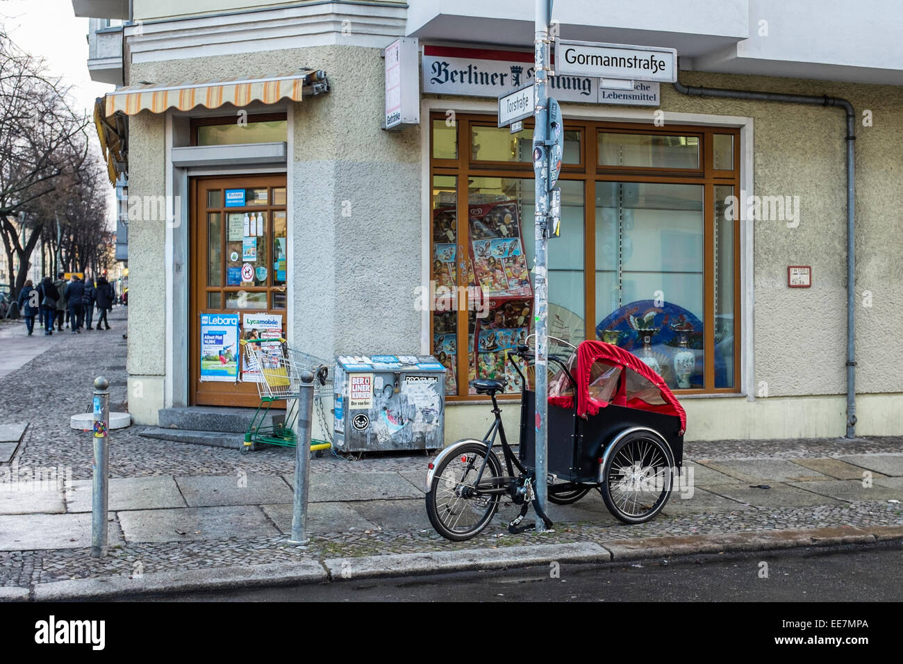 Via Berlino - Bicicletta con bambino veicolo parcheggiato all'esterno comodo negozio, Mitte di Berlino Foto Stock
