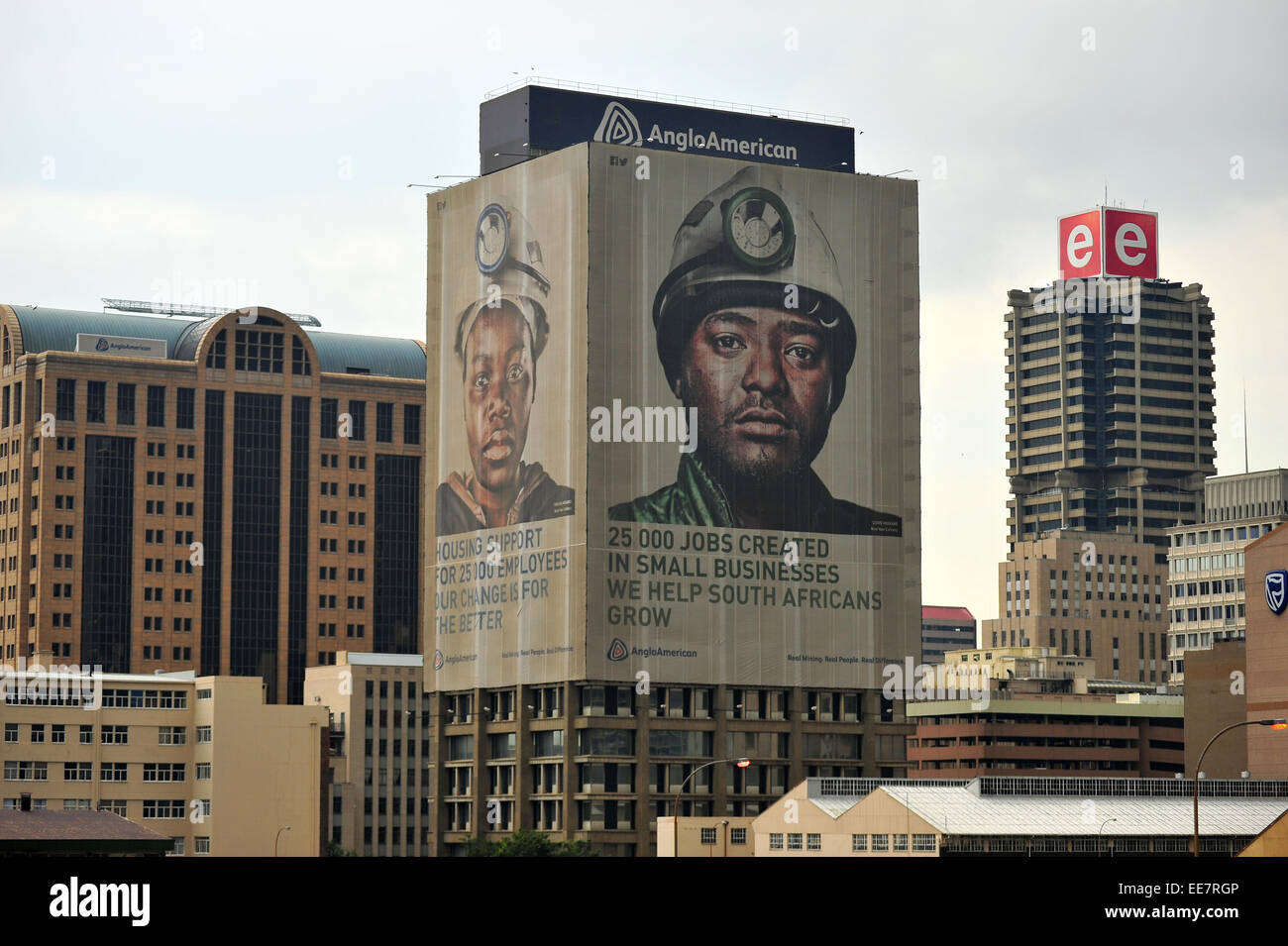 Un gigante immagine di un minatore si blocca sul lato della Anglo American edificio a Johannesburg. Foto Stock