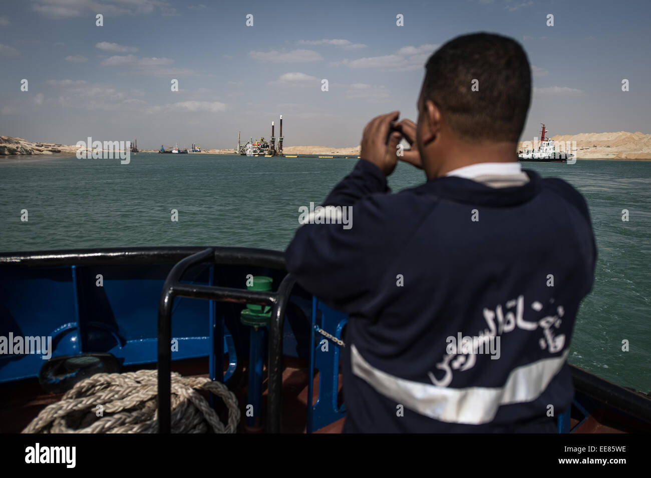 (150114) -- ISMAILIA, 14 Gennaio 2015 -- un membro di un equipaggio della nave prende le foto del sito di costruzione del nuovo canale di Suez, in Ismailia, una città dal Canale di Suez in Egitto, 14 gennaio 2015. L'Egitto ha lanciato il nuovo progetto navigabile in agosto 2014, e la costruzione è stata ordinata dal Presidente egiziano Abdel-Fattah al-Sisi per essere completata in un anno. (Xinhua/Pan Chaoyue) Foto Stock