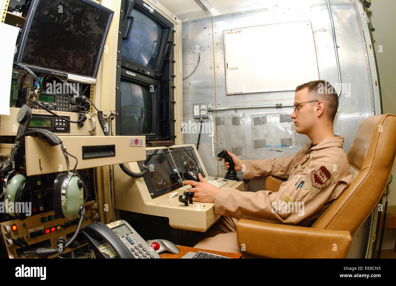 Airman 1. Classe Kyle ponti a condurre una sorveglianza o missioni di ricognizione a distanza il funzionamento di un RQ-1 Predator dalla console operatore presso il Drone stazione di controllo di terra a Balad Air Base, Iraq. Vedere la descrizione per maggiori informazioni. Foto Stock
