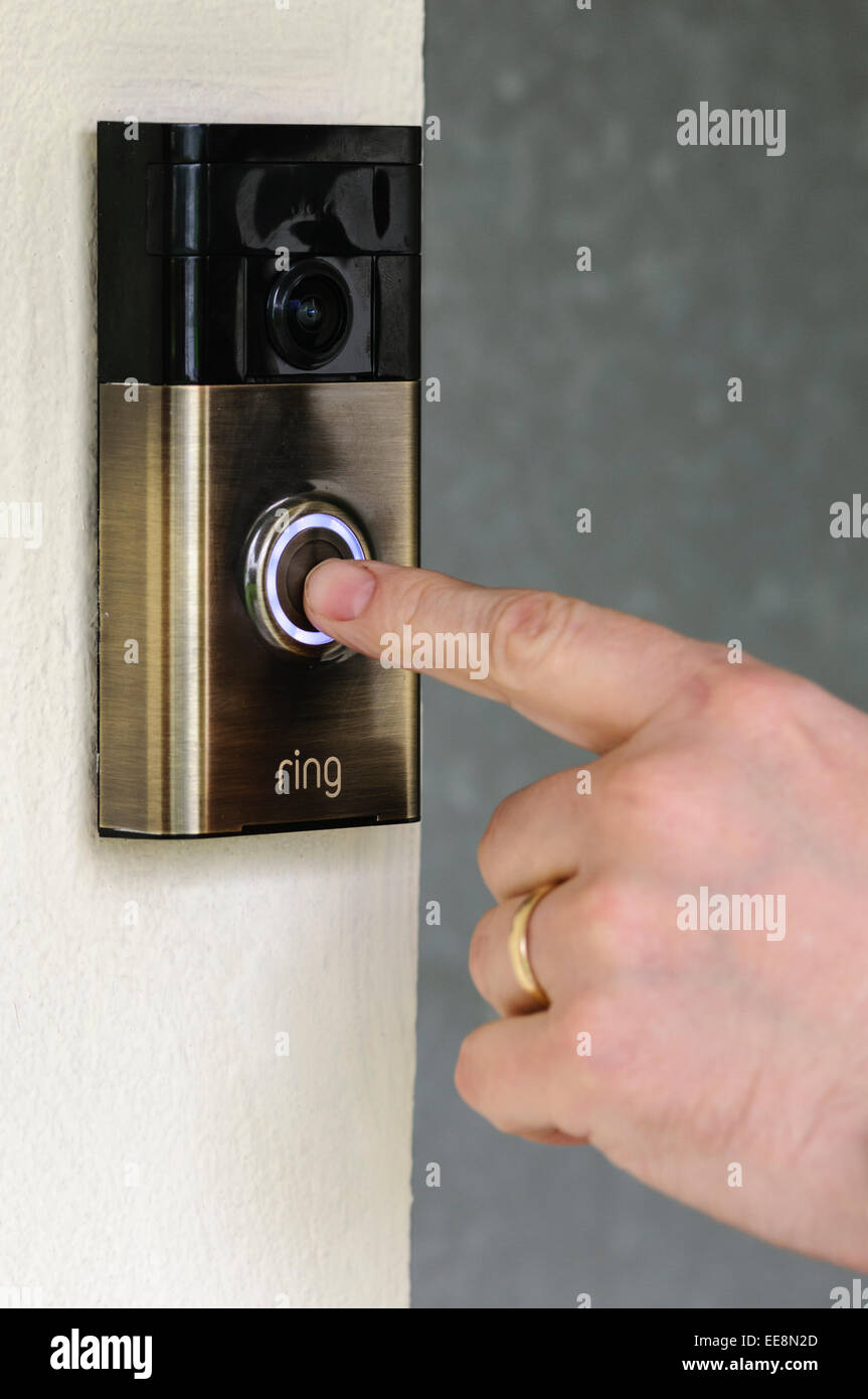 Un uomo preme il pulsante su un 'Ring' internet video campanello da ring.com. Foto Stock