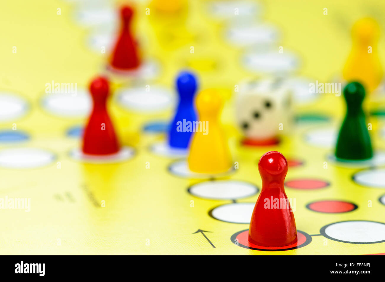 Pezzi e una matrice su un Ludo gioco di bordo Foto Stock