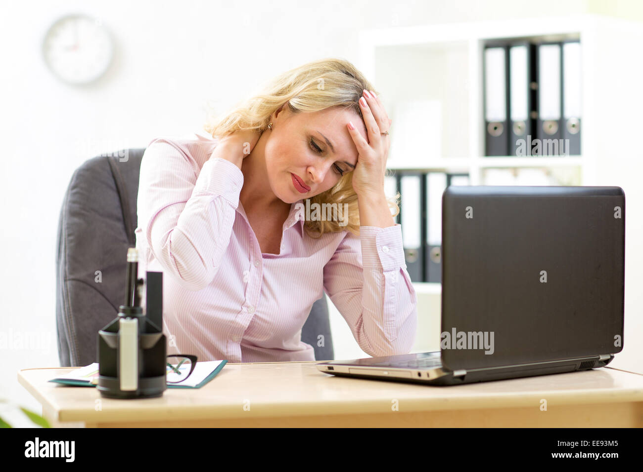 Business donna con mal di testa avente lo stress in ufficio Foto Stock