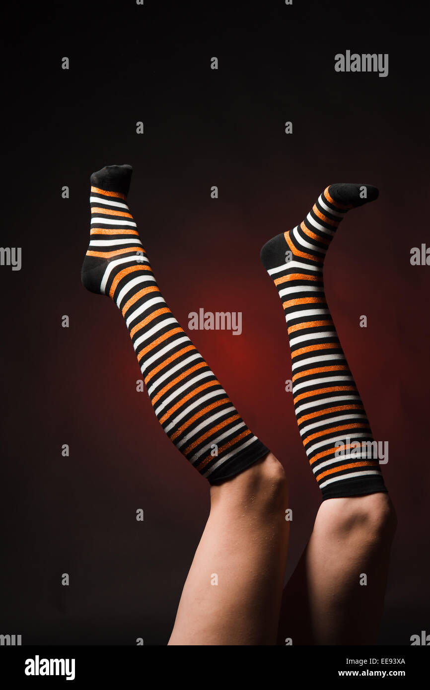 Piuttosto le gambe in una lunga multi-calze colorate Foto Stock
