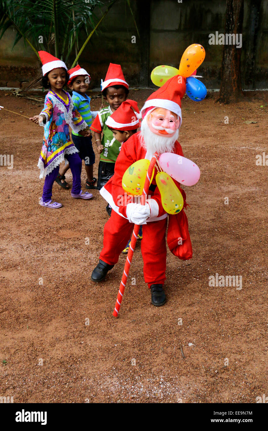 Ragazzi delle scuole festeggiano il Natale in Kerala, India indossando babbo natale costume Foto Stock