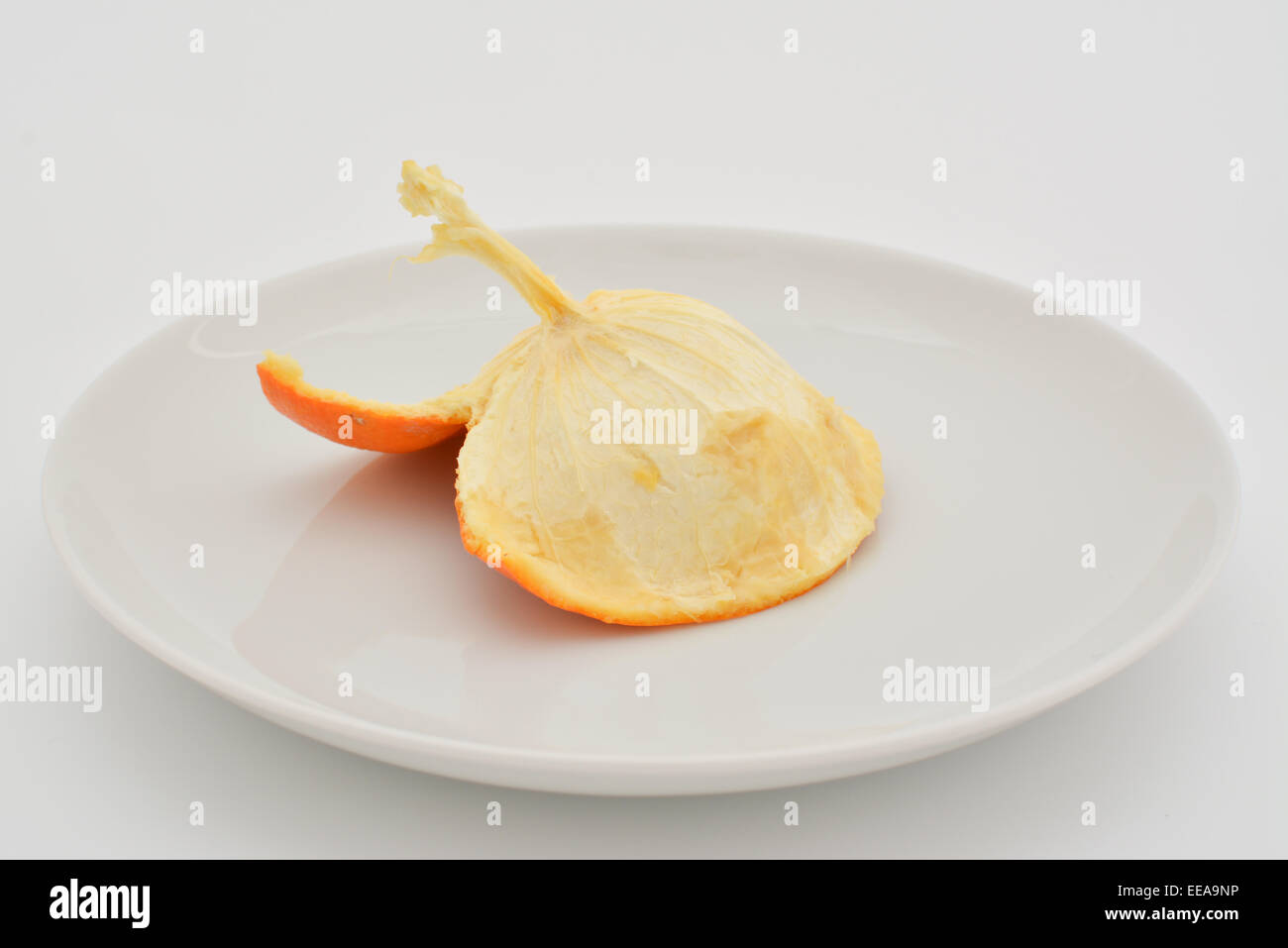 All'interno della pelle di un mangiato arancione su una piastra bianca Foto Stock