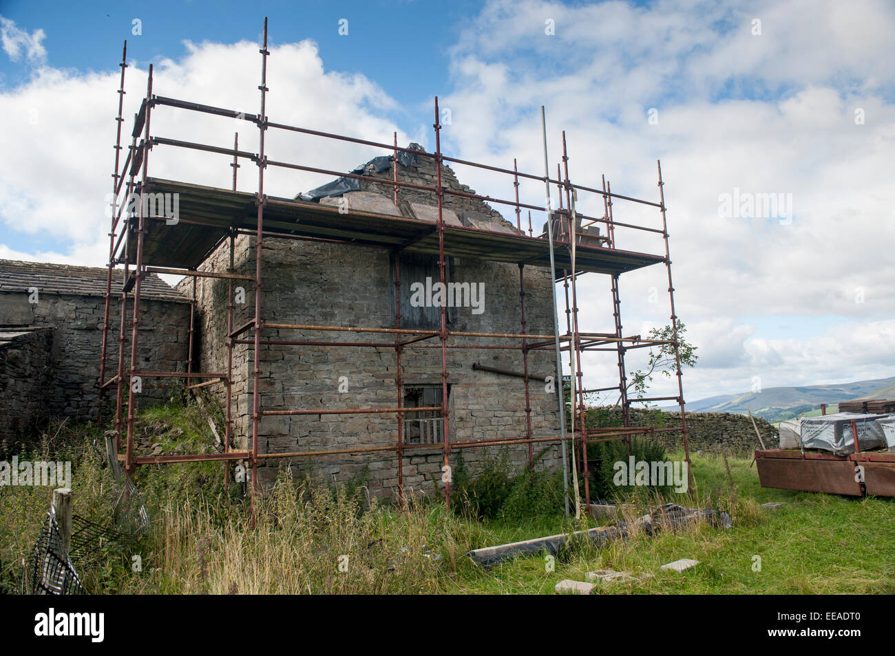 Fienile con autorizzazione di pianificazione per convertire in un cottage con i ponteggi intorno a. Hawes, North Yorkshire, Regno Unito. Foto Stock