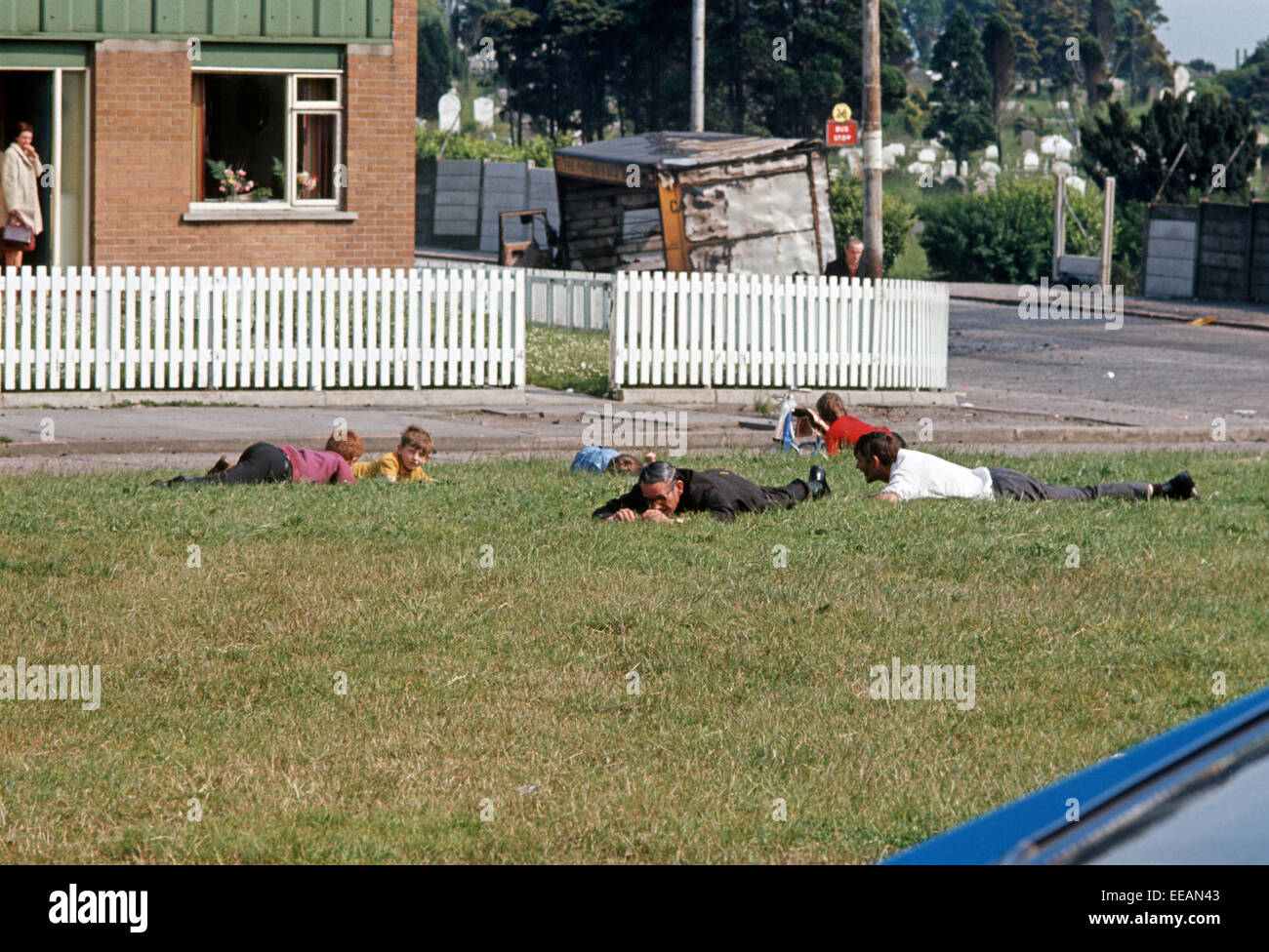 BELFAST, IRLANDA DEL NORD - Giugno 1972. Persone il ricovero a terra durante un'IRA Sniper attentato contro l'esercito britannico nella parte occidentale di Belfast, Irlanda del Nord durante i guai, Foto Stock