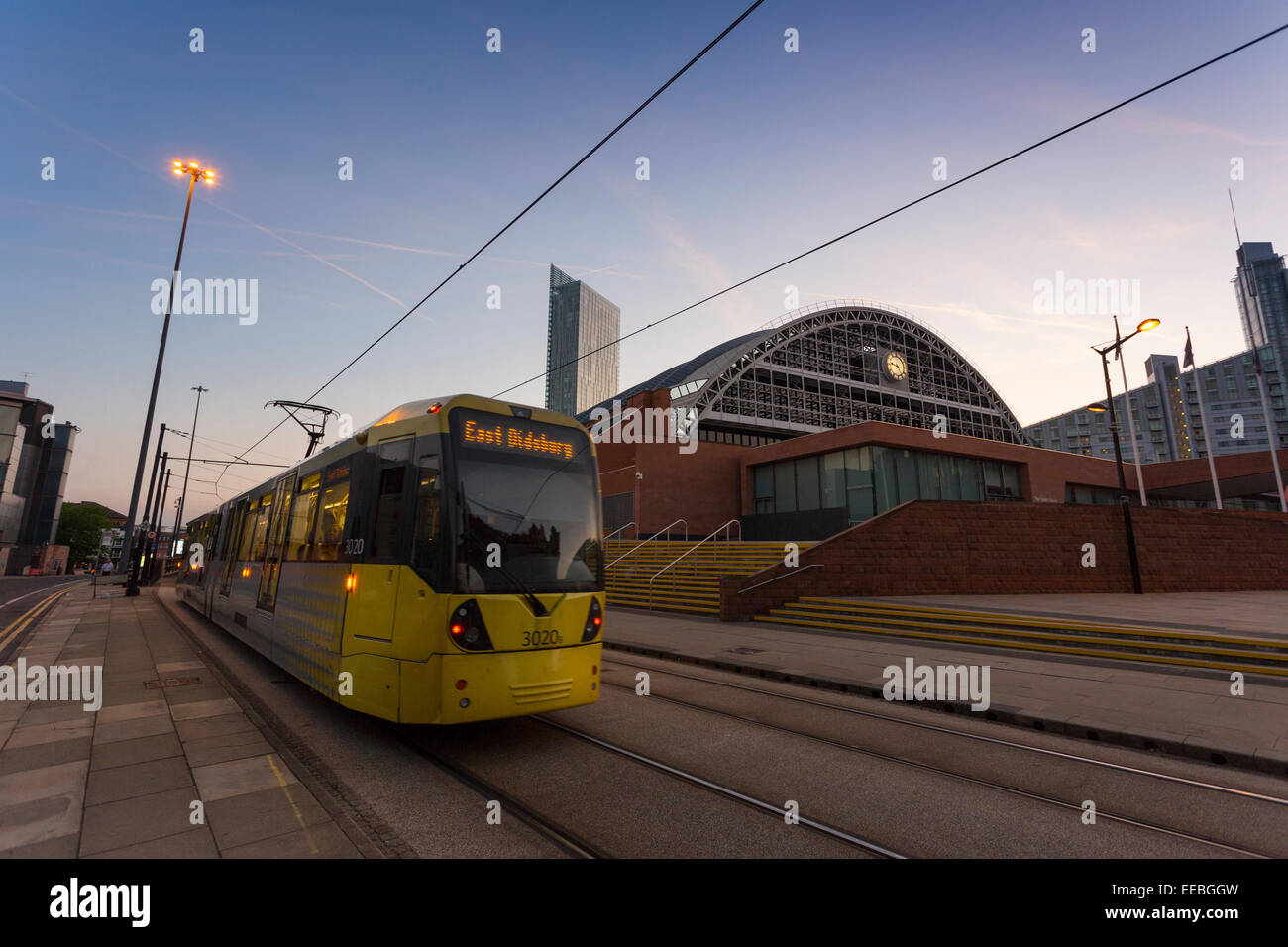 Inghilterra, Manchester, tram Metrolink di Manchester e il Centro Convegni al crepuscolo Foto Stock
