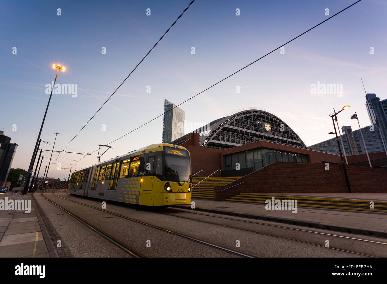 Inghilterra, Manchester, tram Metrolink di Manchester e il Centro Convegni al crepuscolo Foto Stock