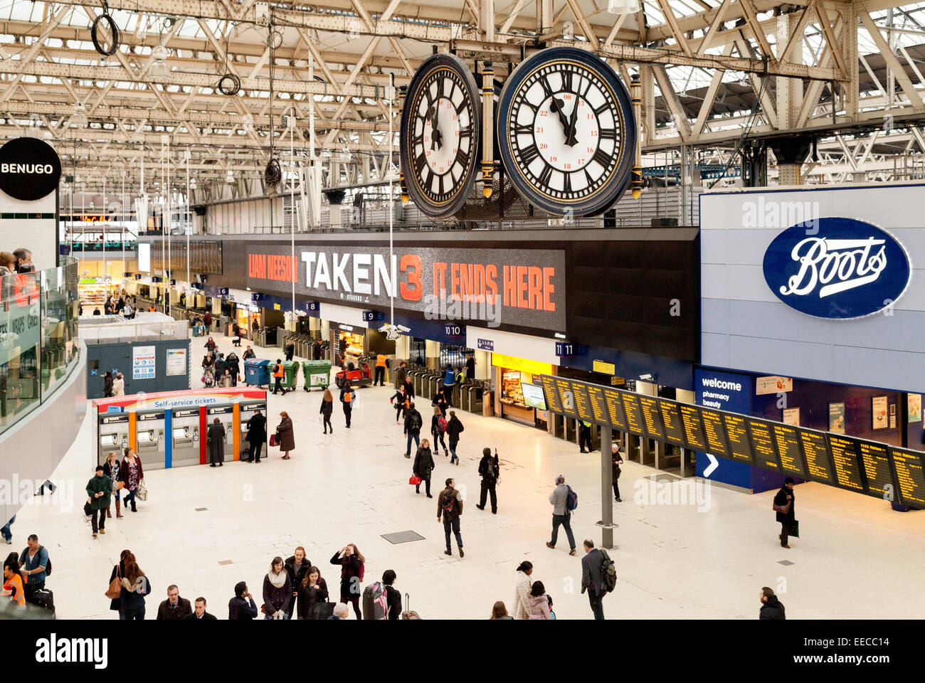 I passeggeri sulla stazione ferroviaria di Waterloo concourse sotto l'orologio, London, England Regno Unito Foto Stock