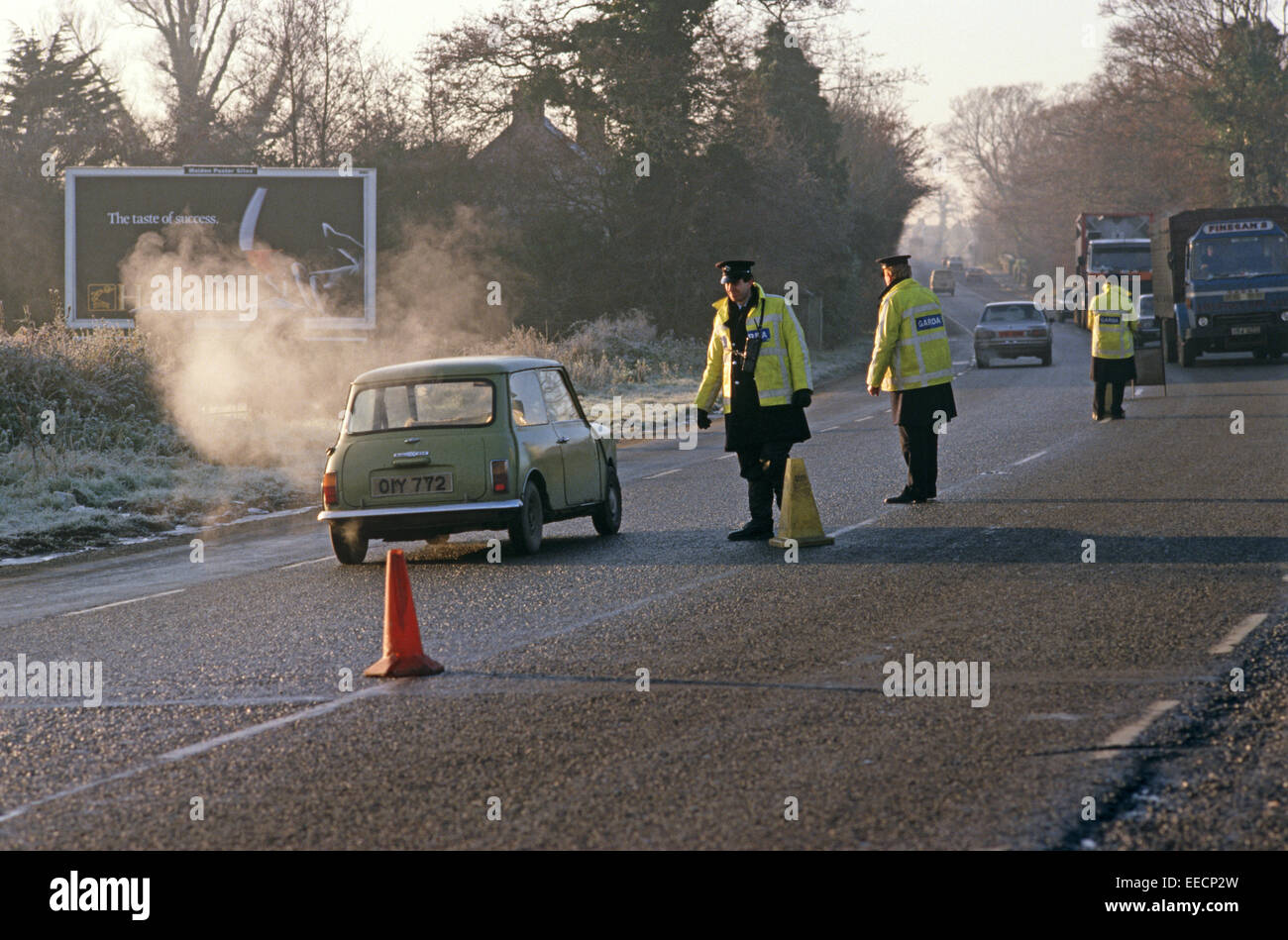 Repubblica di Irlanda, nella contea di Louth - dicembre 1985. Garda, polizia irlandese, checkpoint in Dublino a Belfast Road durante i guai, Irlanda. Foto Stock