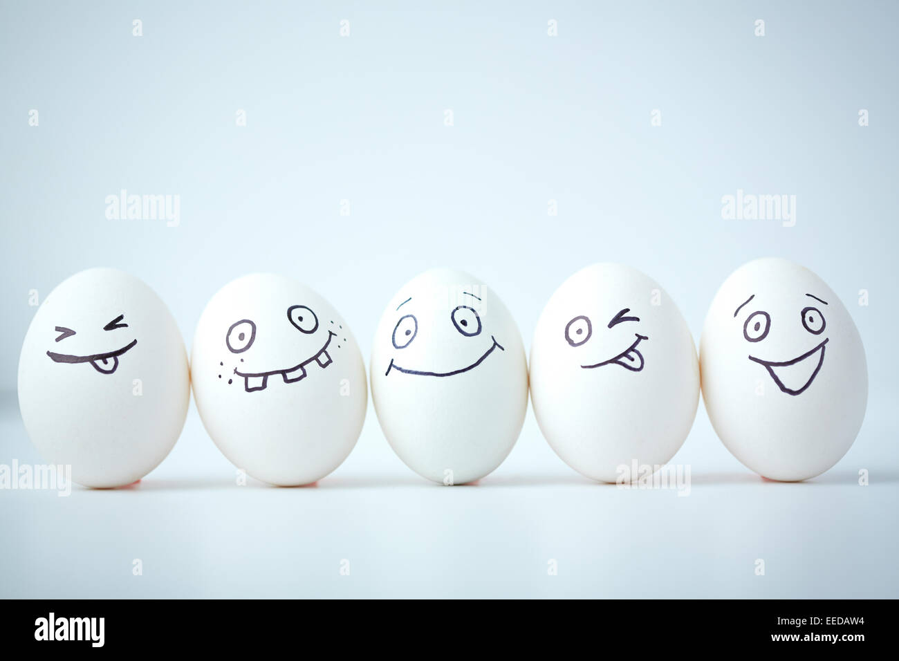 La linea di uova con diverse espressioni del viso Foto Stock