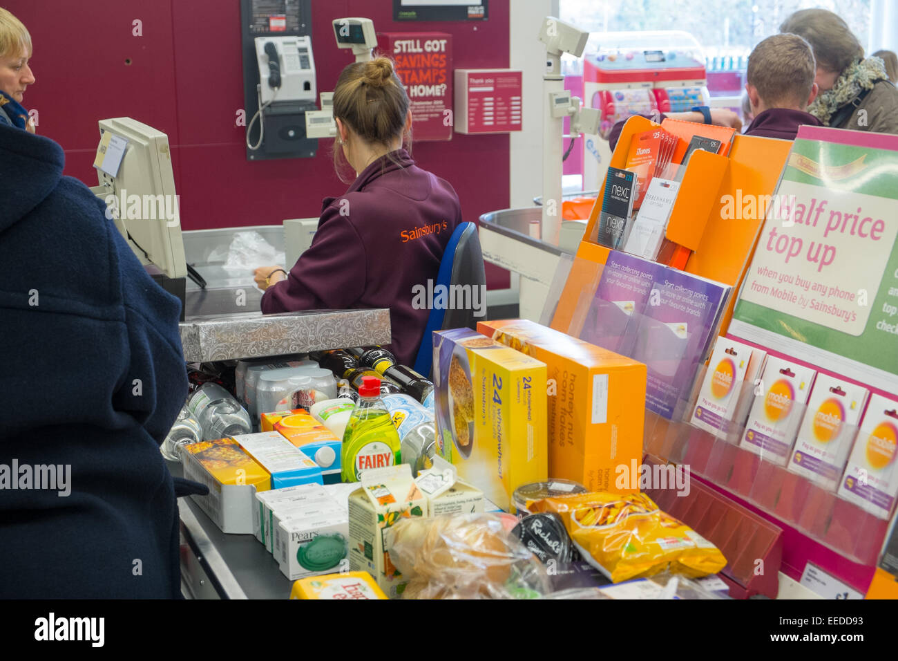 Signora controllo fuori i suoi acquisti presso un negozio Sainsburys in Matlock,Derbyshire,Inghilterra Foto Stock