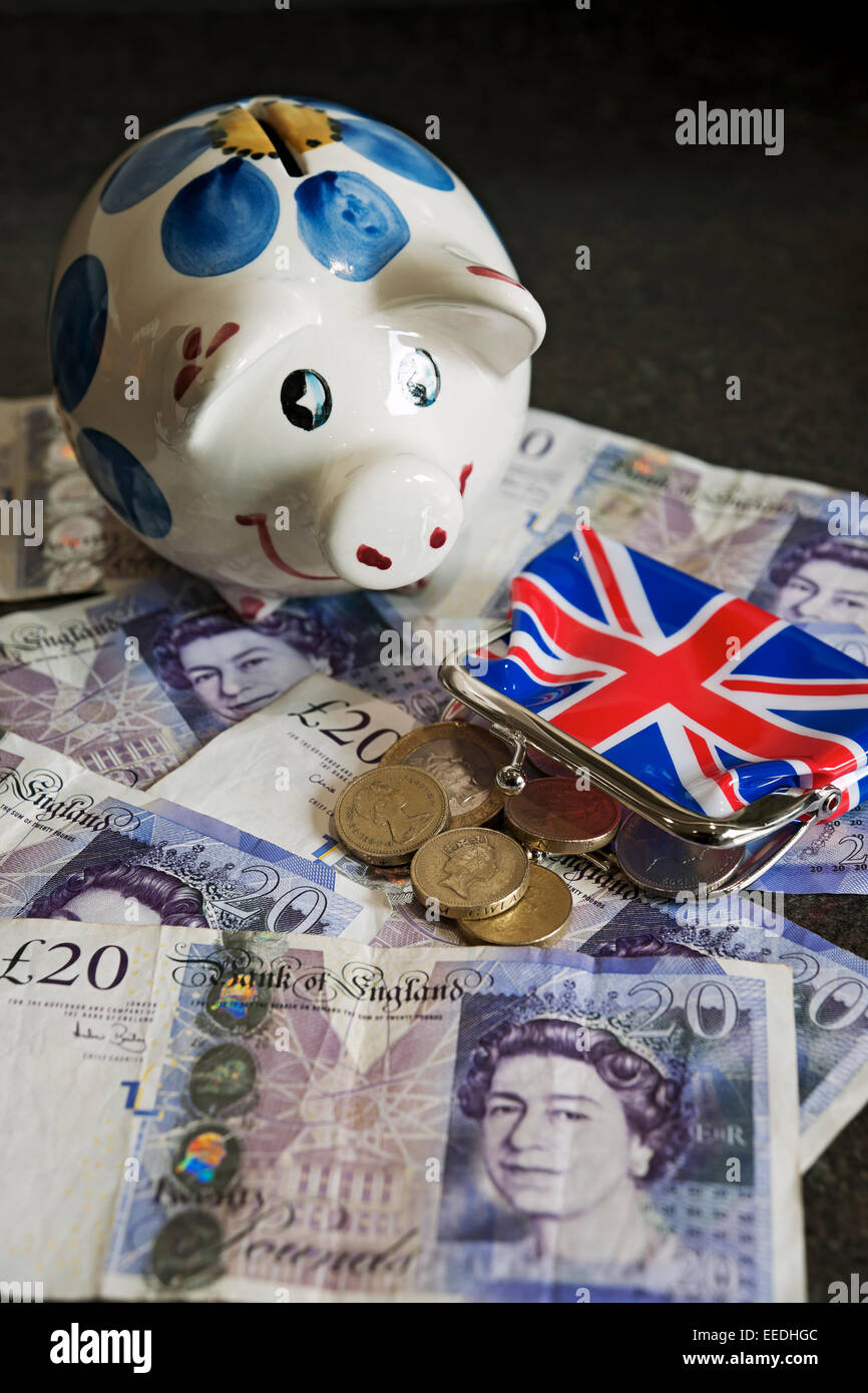 Primo piano di Piggy banca e banconote in valuta inglese banconote in contanti monete finanza business concept Inghilterra Regno Unito GB Gran Bretagna Foto Stock