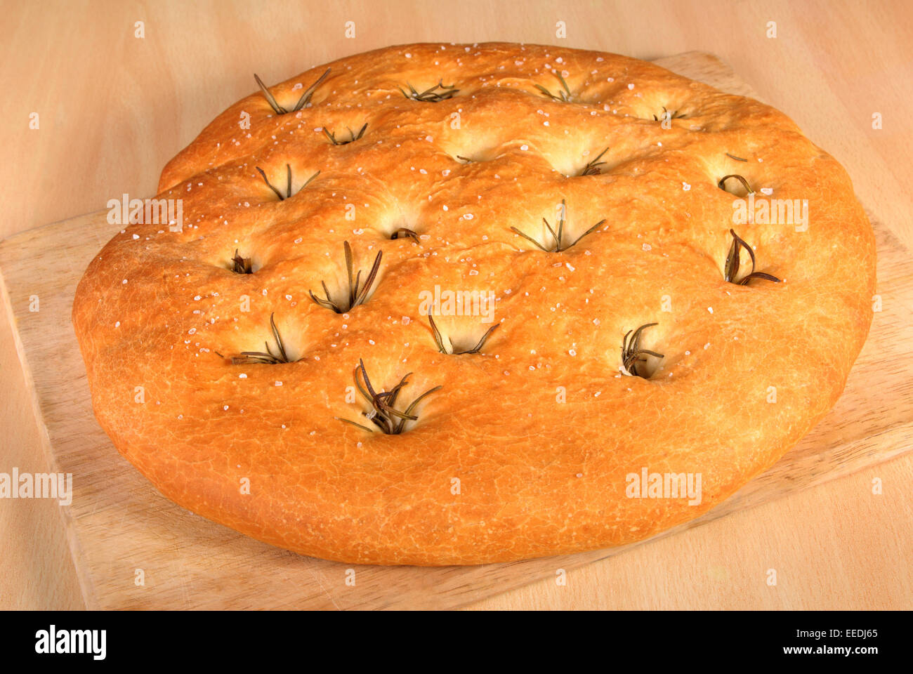 Pane appena sfornato foccacia pane al rosmarino su una tavola di legno Foto Stock