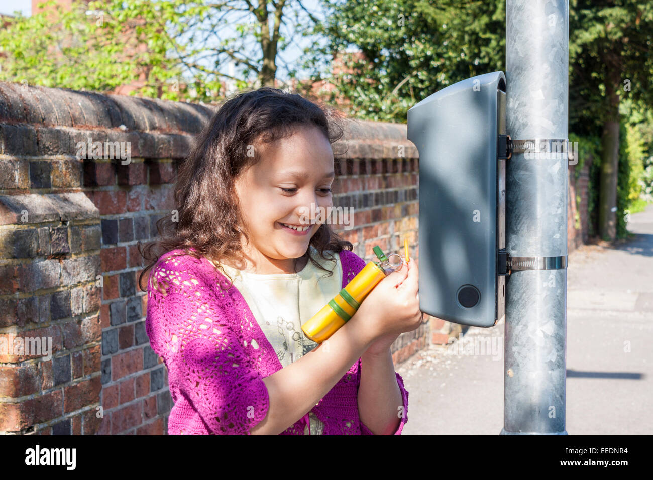 Un bambino tocchi un portachiavi su un "BATTERE LA STRADA' box su un lampost per registrare la distanza camminato. Foto Stock