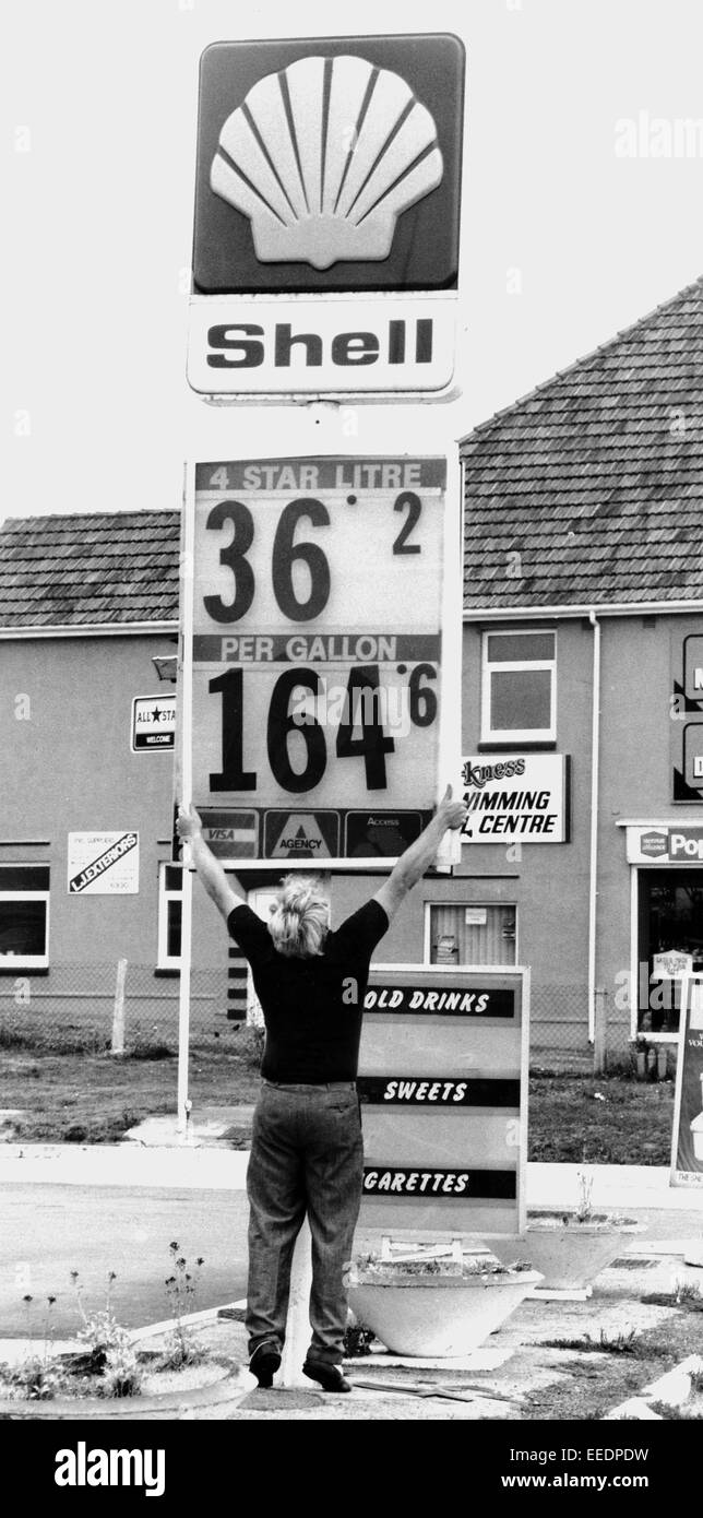 Una donna ad una stazione di benzina nel 1986 le modifiche dei prezzi del carburante sia in litri e galloni - Brighton Regno Unito Foto Stock