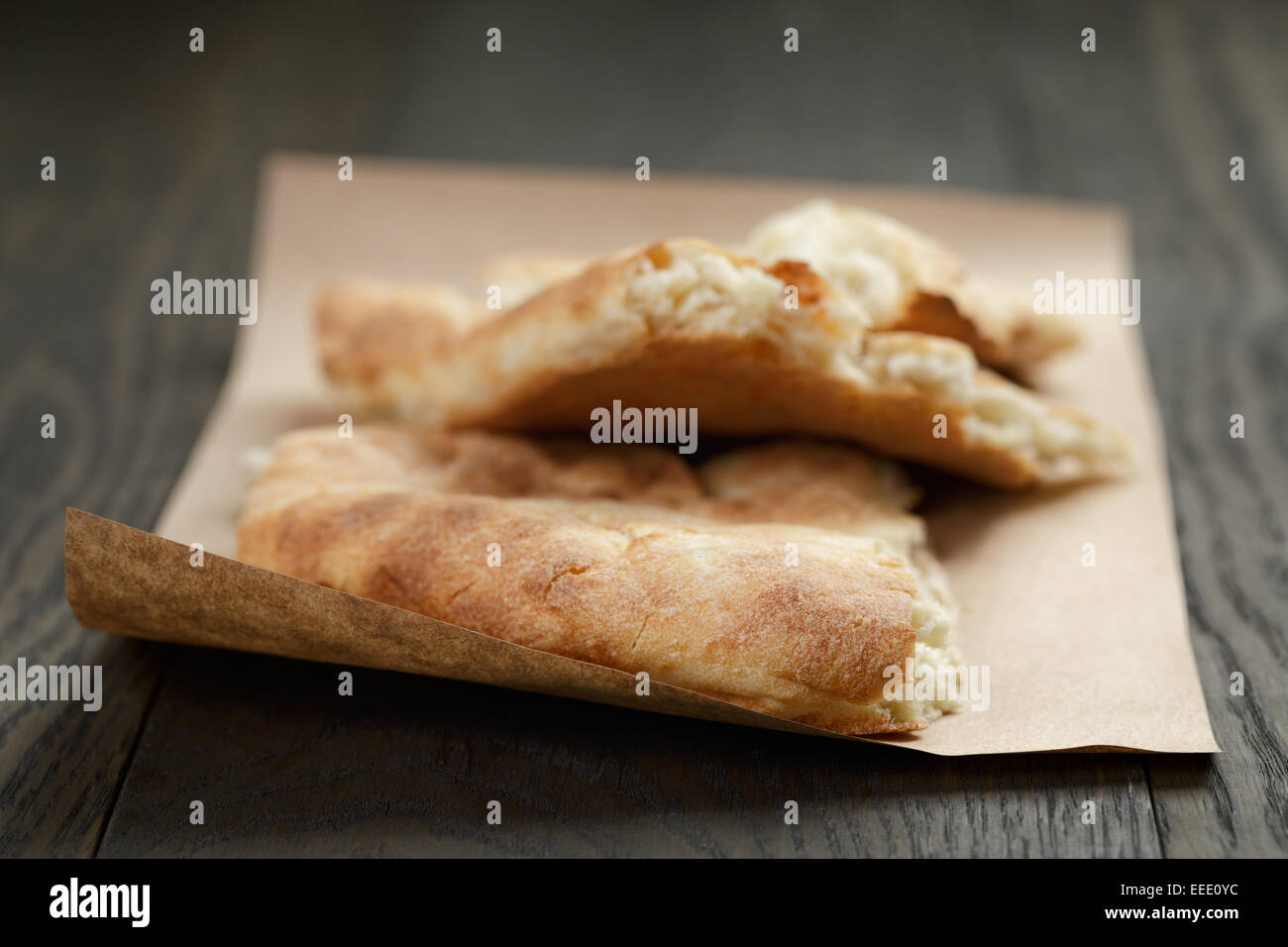 Pane appena sfornato georgian pane pita su carta, legno tavolo in legno di quercia Foto Stock