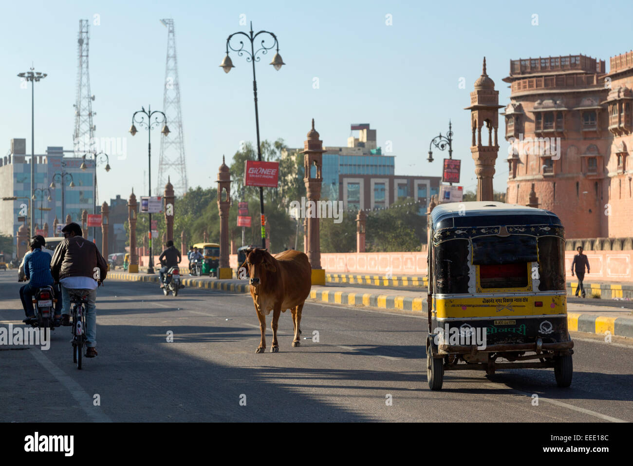 India Rajasthan, Bikaner e rikshaw, ciclomotori e vacca al di fuori di Junagarh Fort Foto Stock